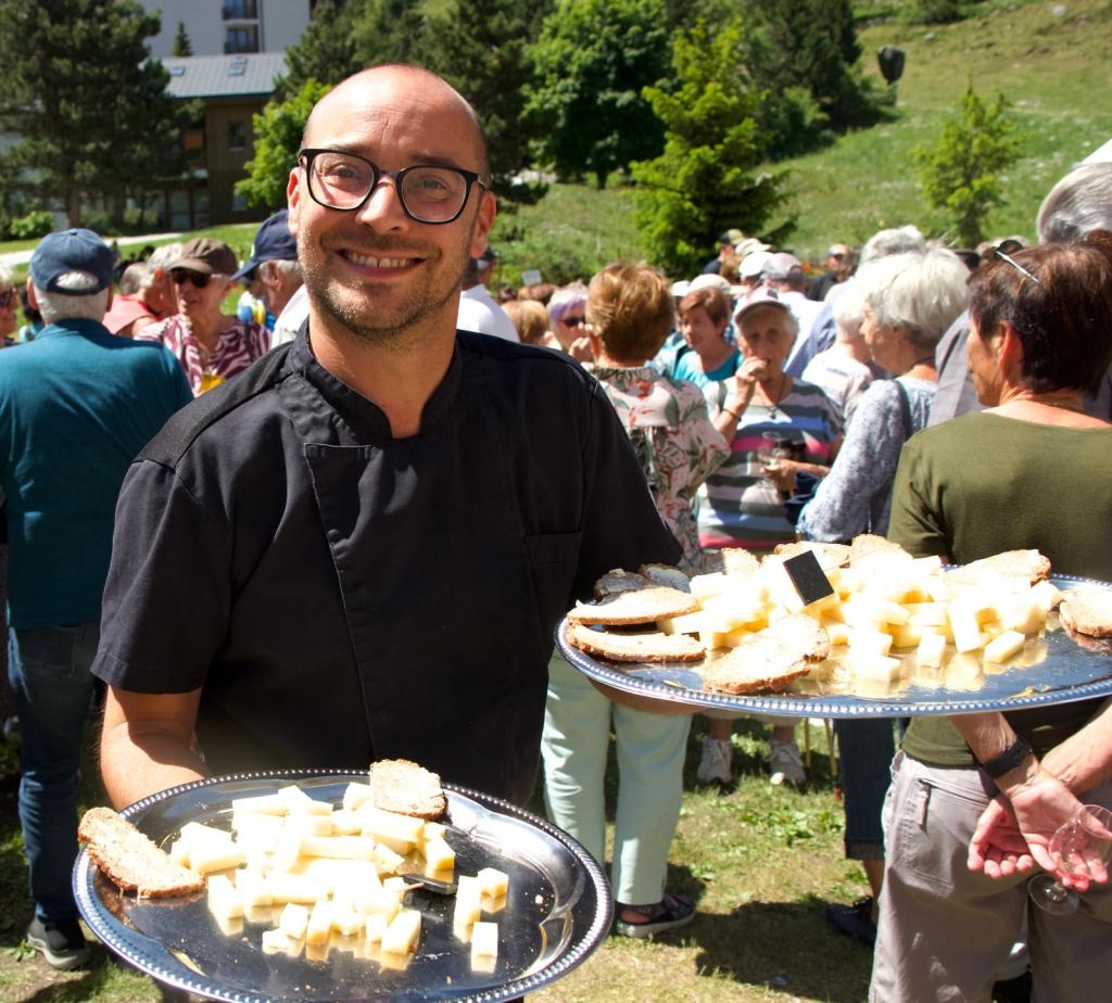 Le chef Thibaud servant des plateaux de fromage lors d'une fête d'été à Siviez